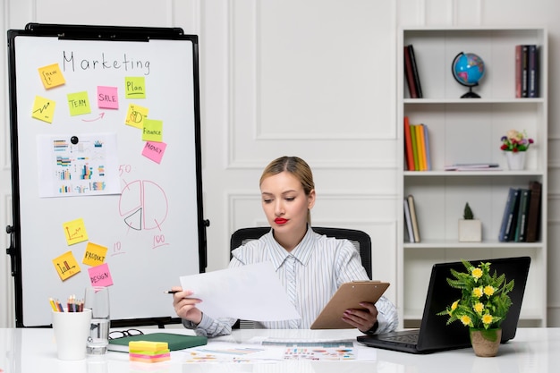 Marketing smart cute business lady in striped shirt in office looking at results and analysing