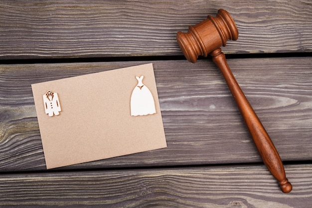 Marriage gavel and copy space on beige paper. Brown wooden hammer on wood.