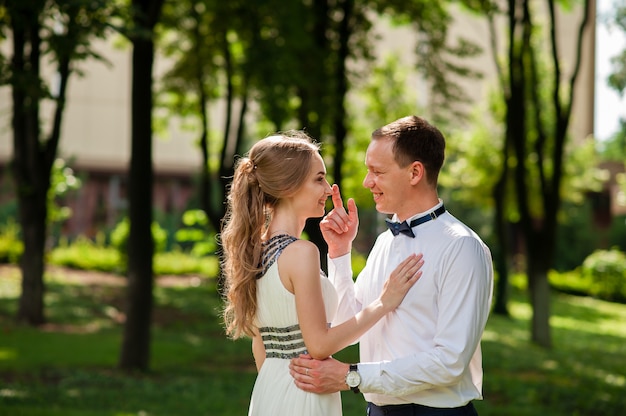 A married couple is walking and hugging in the park.