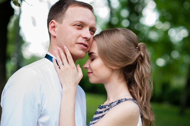 married couple is walking and hugging in the park.