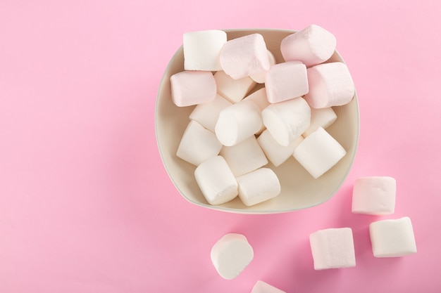 Marshmallow in bowl on pastel pink background.