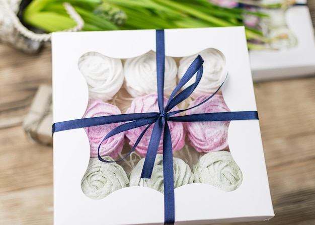 Marshmallow in a gift box on a wooden background Sweet gift