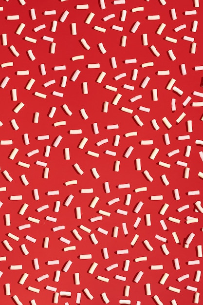 Marshmallow on a red background. Food pattern. Sweet pattern. Flat lay