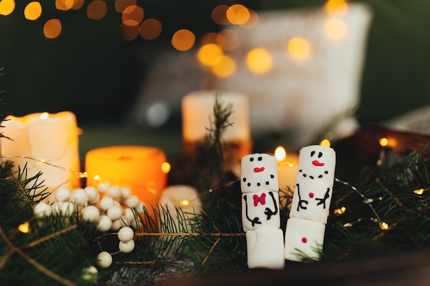 Marshmallow snowmans, bokeh lights, christmas decor, candles.