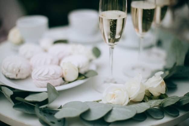 Marshmallows and glasses of champagne on a white table Wedding decor