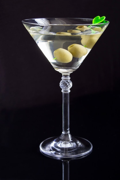 Martini with green olives in a glass