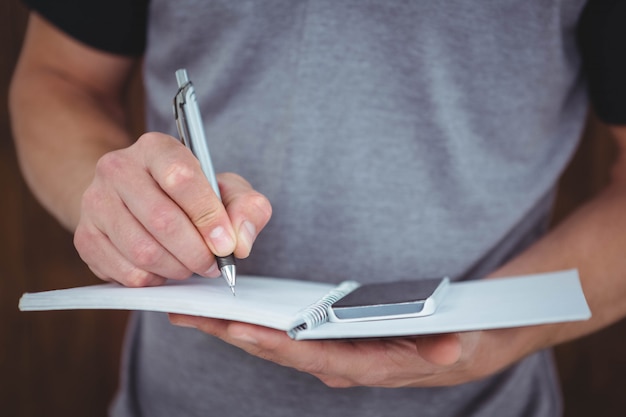 Masculine hands writing on notebook