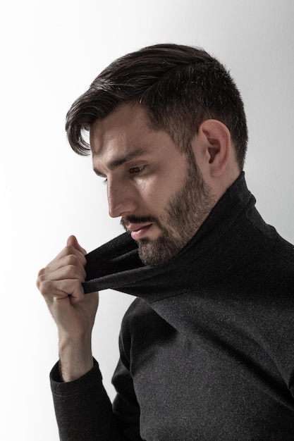 Masculine man touching the collar of his polo neck