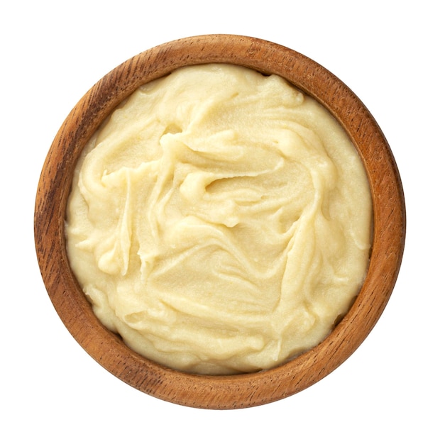 Mashed potato puree in wooden bowl isolated on white background top view