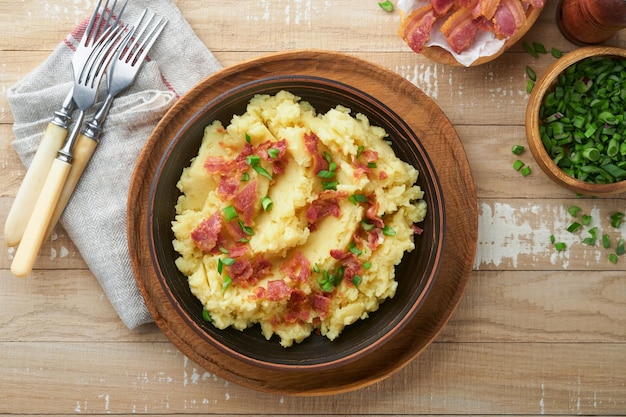 Mashed potatoes Bacon mashed potatoes with green onion pepper and cheddar cheese in bowl on old wooden backgrounds Delicious creamy mashed potatoes Top view