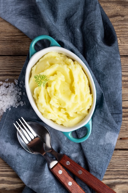 Mashed potatoes in bowl on wooden rustic. Top view.