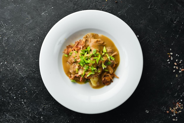 Mashed potatoes with veal sauce and meat on a plate Top view