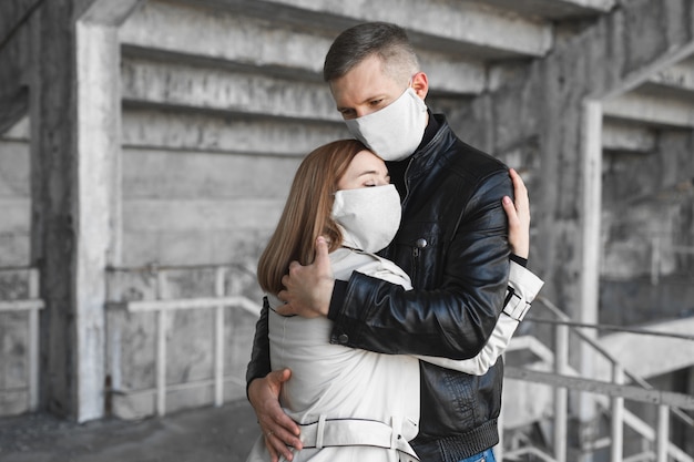 Masked man and woman embrace