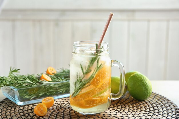 Mason jar with fresh rosemary drink on wicker mat