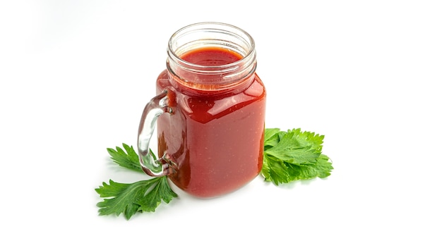 Mason jar with tomato juice and parsley.