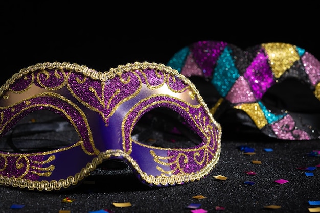 Masquerade mask with confetties on black background