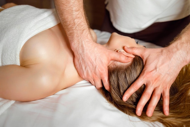 Massage the head and neck to a woman in spa