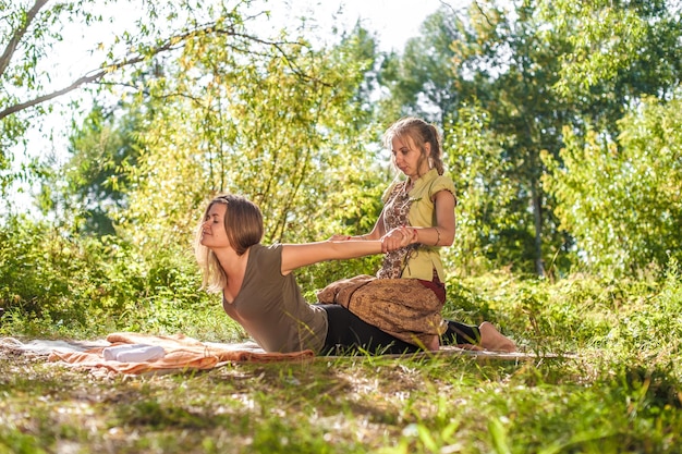 Massage professional demonstrates refreshing massaging methods in the sunlight.