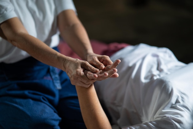 Massage and spa relaxing treatment of office syndrome traditional thai massage style Asain senior female masseuse doing massage treat hand back pain arm pain foot and stress for old woman tired