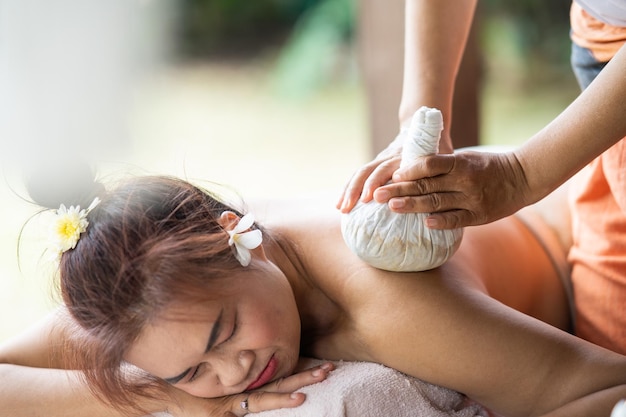 Massage spa relaxing treatment of office syndrome traditional thai massage style Asian female massage traditional compress for hot massage back pain arm pain and stress for woman tired from work