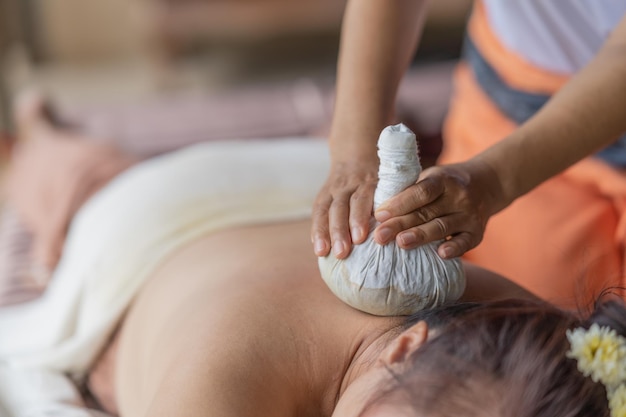 Massage spa relaxing treatment of office syndrome traditional thai massage style Asian female massage traditional compress for hot massage back pain arm pain and stress for woman tired from work