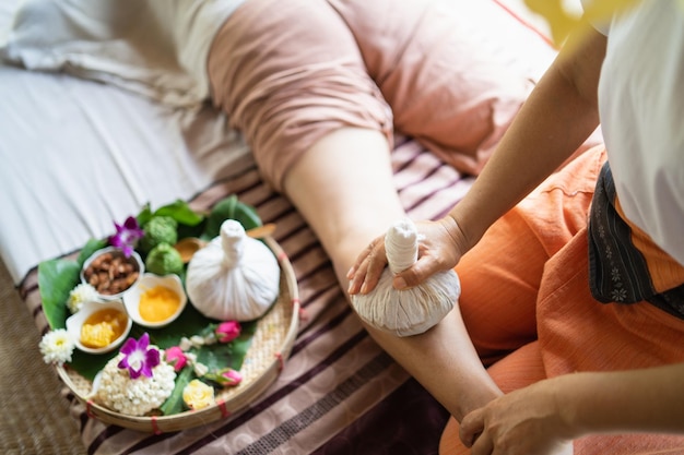 Massage spa relaxing treatment of office syndrome traditional thai massage style Asian female massage traditional compress for hot massage leg pain arm pain and stress for woman tired from work