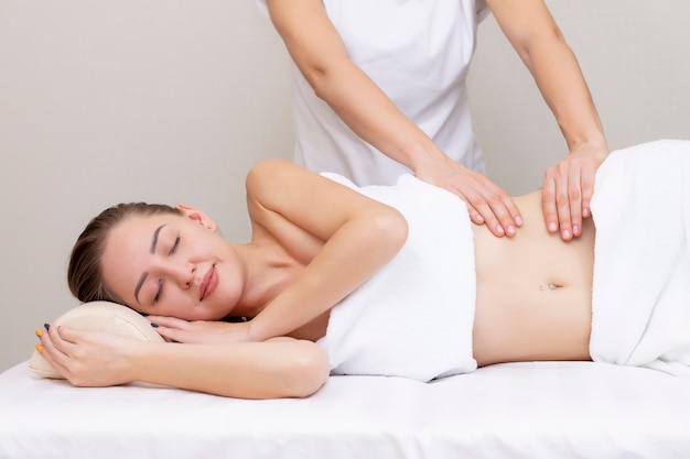 Massage Therapist Massaging a Womens Stomach. Massage and body care. Spa body massage woman hands treatment.