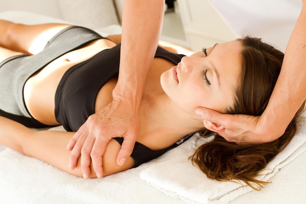 Massages and physiotherapy to a woman in her neck