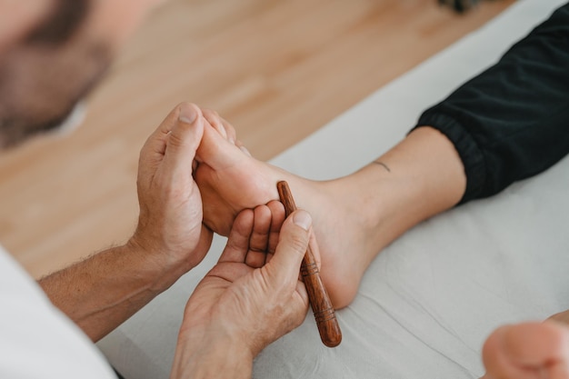 Massaging the foot with a wooden stick