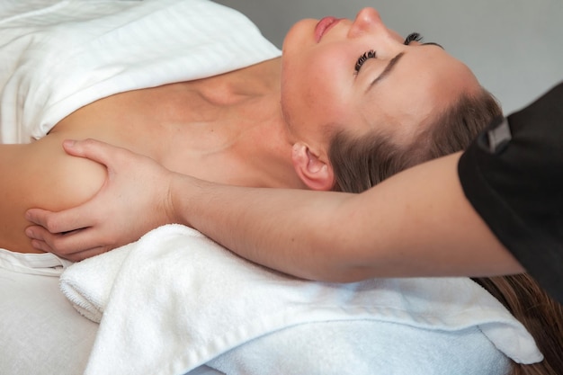 Massaging therapist makes shoulders therapy mass for woman Massage female in SPA salon