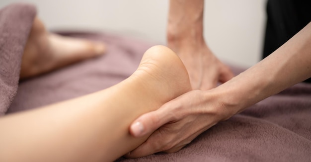 Masseur Providing a Deep Tissue Leg Massage at Spa