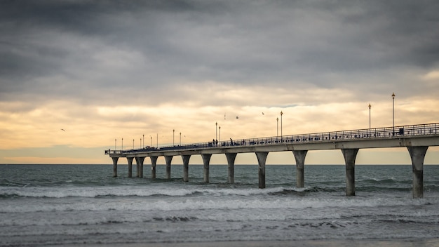 massive concrete pier leading to horizon surrounded by ocean during sunset christchurchnew zealand