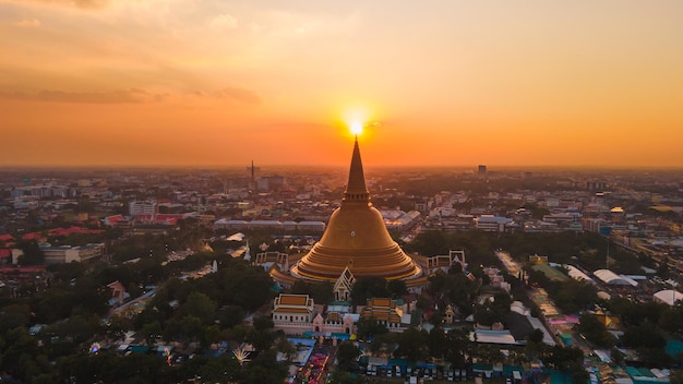 A massive golden pagoda Located in the sunset community of Phra Pathom Chedi Nakhon Pathom Thailand The measurement was made public Thailand aerial view of a road roundabout with auto lots Lovely