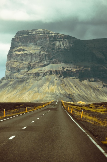 Massive mountain with canyon on Iceland end of an infinite road View from the road during a trip through Icelandic wild areas Boho backpacking traveling style nature background concept Colorful