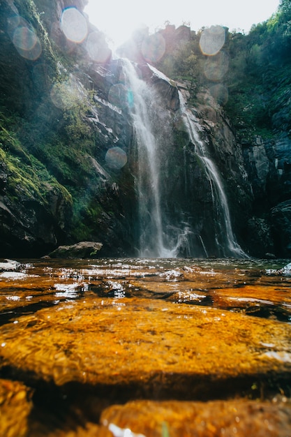 Massive waterfall over some rocks during a super sunny day