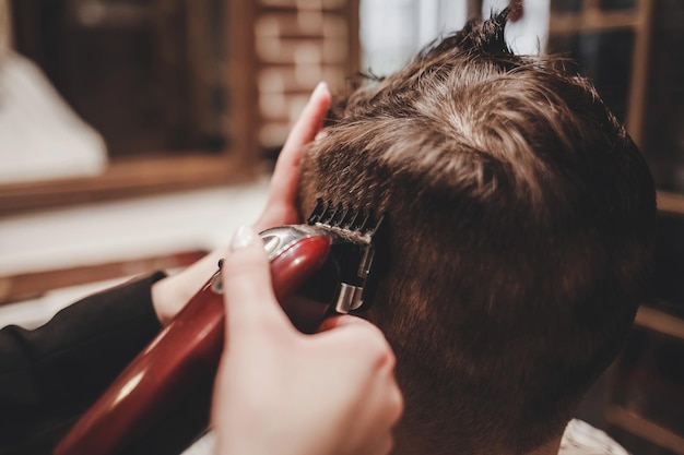 Master Barber does the hairstyle to guy