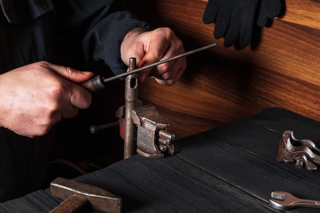 Master grinds the part with a file in a vice. Working environment in the workshop