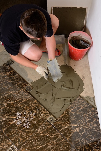 Master husband presses a spatula glutinous solution to the cement surface