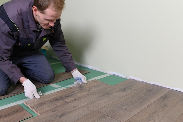 The master is laying the laminate the man is doing the repair of the floor