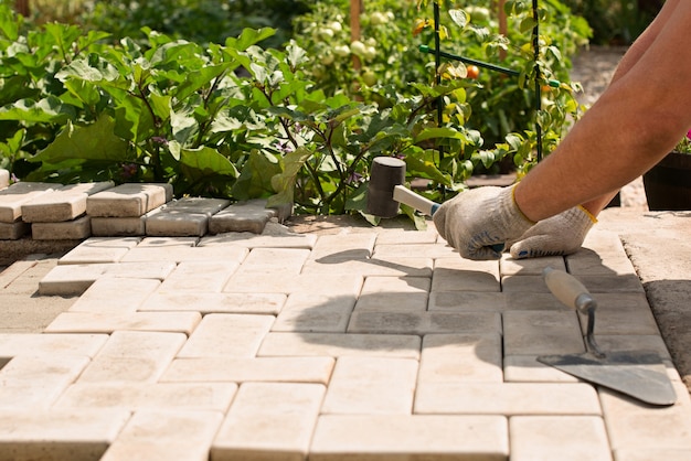 The master  lays paving stones in layers