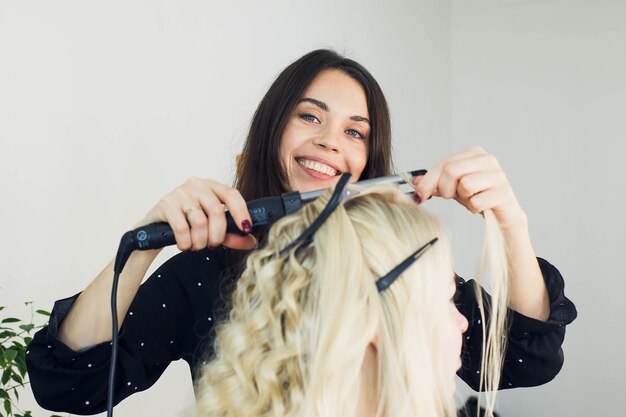 The master makes a hairstyle for a girl, beautiful curls