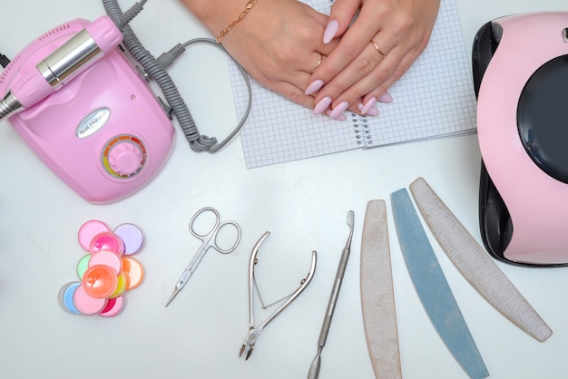 the master makes a manicure in the salon female hands close up