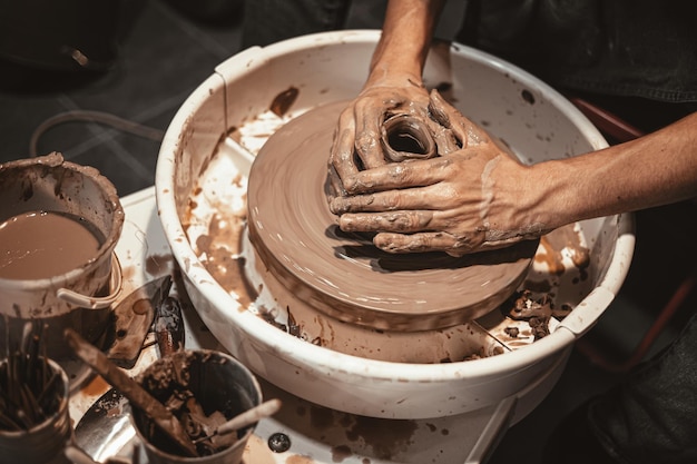 Master of pottery hancraft work modeling hand made clay on potter wheel in pottery workshop