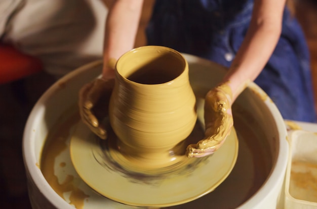 The master with the child molds a clay jug.