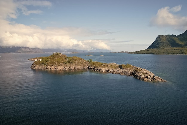 Masterpieces of nature Island stony surrounded sea water in Norway Best nature places to visit in Norway Seascape with island on sunny day Serenity and idyllic Island stony cliffs coast