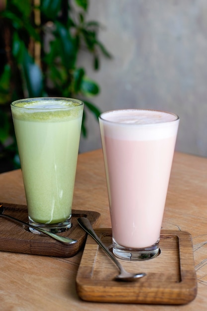 Matcha latte and raspberry latte in a glass.