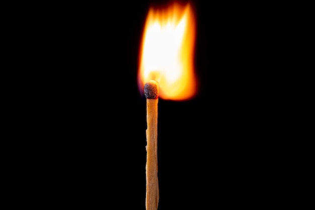 Matchstick burning in detail seen through a macro lens black background selective focus