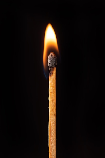 Matchstick burning in detail seen through a macro lens black background selective focus