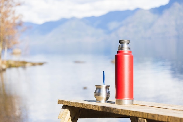 Mate and a thermo full of water ready to be drunk on a calm lake place