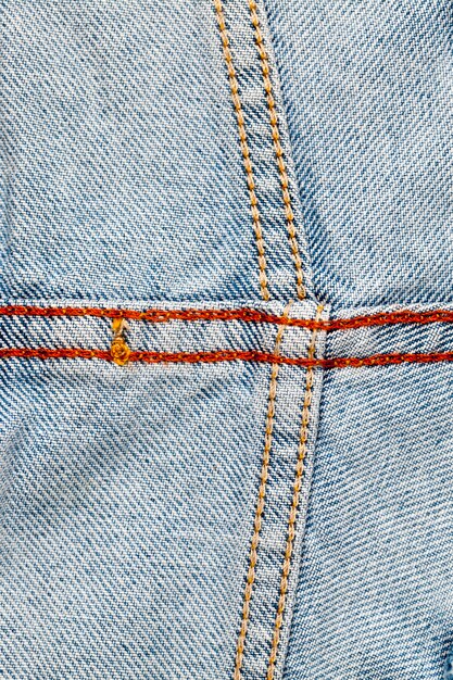 Material made of blue denim with seams, details of materials made of blue denim sewn from parts